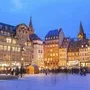 Straßburger Weihnachtsmarkt mit beleuchtetem Weihnachtsbaum und historischen Gebäuden.