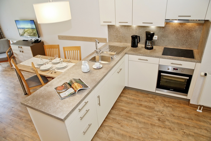 Moderne Küche mit Esstisch und Geräten in einer hellen Wohnung.