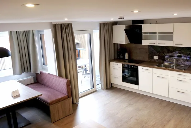 Moderne Küche und Essbereich in einem hellen Wohnbereich mit Holzböden.