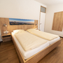 Schlafzimmer mit Doppelbett und Holzmöbeln in einem Ferienhaus.