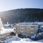 Hotelgebäude im Winter vor bewaldeten Hügeln in Radstadt.