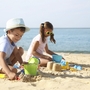 Kinder spielen am Strand im Sand vor dem Meer.
