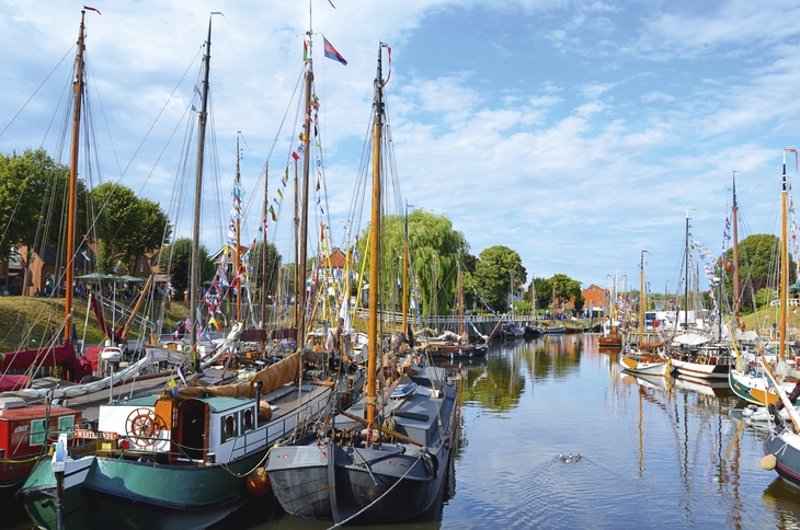 Segelschiffe im Hafen von Carolinensiel bei blauem Himmel.