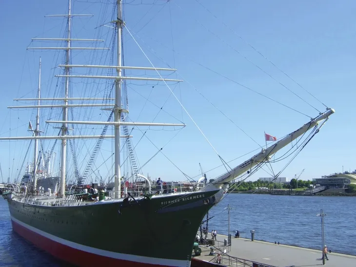 Großes Segelschiff im Hafen bei klarem Himmel.