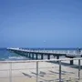 Steg am Timmendorfer Strand führt ins Meer bei klarem Himmel.