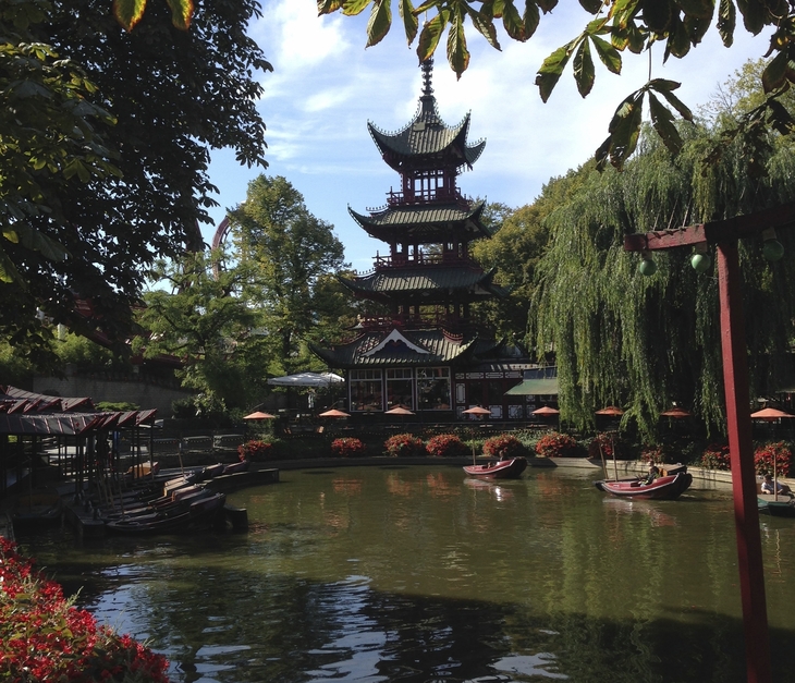 Chinesischer Turm im Garten mit Teich und Bäumen in Kopenhagen.