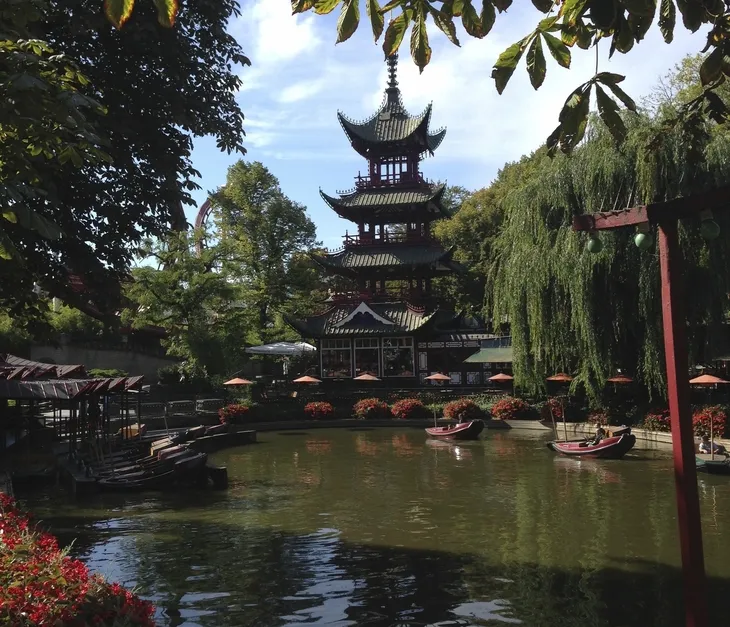 Chinesischer Turm im Garten mit Teich und Bäumen in Kopenhagen.