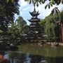 Chinesischer Turm im Garten mit Teich und Bäumen in Kopenhagen.