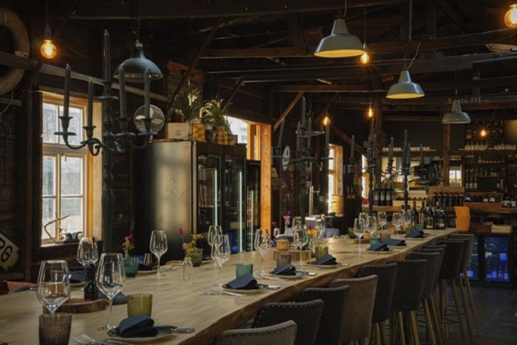 Ein gedeckter Tisch in einem rustikalen Restaurant mit gedämpfter Beleuchtung.