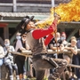 Mann in Westernkleidung führt eine Feuershow vor Publikum auf.