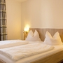 Helles Schlafzimmer mit Doppelbett und Nachttischlampen in der Ferienanlage Braunlage.