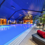 Innenansicht eines Schwimmbads im Eurostrand Resort mit Liegen und Palmen.