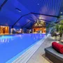 Innenansicht eines Schwimmbads im Eurostrand Resort mit Liegen und Palmen.