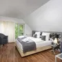 Modernes Schlafzimmer mit Doppelbett, zwei Sesseln und großen Fenstern im Eurostrand Resort.