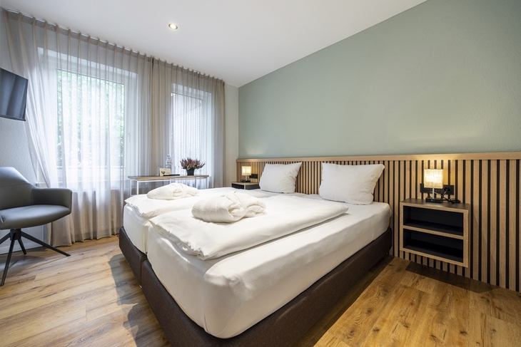 Modernes Hotelzimmer mit Doppelbett und Fenster im Eurostrand Resort Fintel.