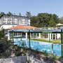 Außenansicht des Ostseehotels Waldschlösschen mit Pool und Garten bei Tageslicht.