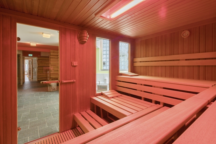 Innenansicht einer modernen Sauna mit hölzernen Sitzbänken im Best Western Plus Ostseehotel.