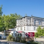 Fachwerkgebäude des Best Western Plus Ostseehotels Waldschlösschen in Prerow, umgeben von Bäumen.
