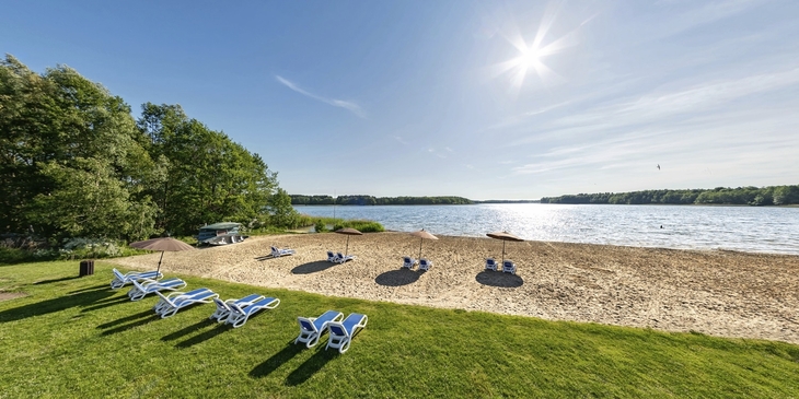 Strand mit Liegestühlen am See bei Sonnenschein im Ahorn Seehotel Templin