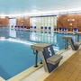 Hotel-Innenpool mit blauen Stühlen und Startblöcken am Beckenrand