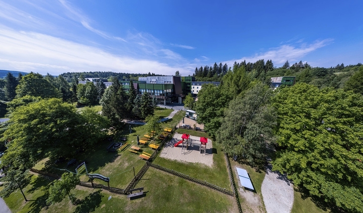 Luftaufnahme des Ahorn Waldhotels mit Biergarten und Spielplatz in grüner Umgebung