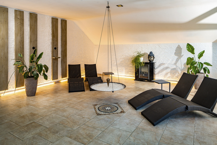 Wellnessbereich mit Liegen und Pflanzen im Hotel Poppenhausen Rhön Garden.