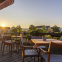 Außenterrasse mit Tischen und Stühlen bei Sonnenuntergang im Eurostrand Resort Moseltal.
