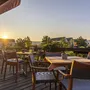Außenterrasse mit Tischen und Stühlen bei Sonnenuntergang im Eurostrand Resort Moseltal.