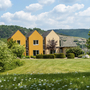 Außenansicht des Leiwen Eurostrand Resorts im Moseltal mit grüner Wiese und Gebäuden.