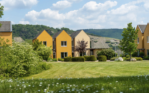 Außenansicht des Leiwen Eurostrand Resorts im Moseltal mit grüner Wiese und Gebäuden.