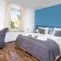 Modernes Schlafzimmer mit blauem Akzent, Doppelbett und Tageslicht im Eurostrand Resort Moseltal.