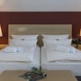 Hotelzimmer mit zwei Einzelbetten, Nachttischen und Stehlampen.