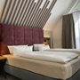 Doppelzimmer mit modernem Kopfteil und Fenster im Hotel Mainpromenade Karlstadt.