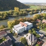 Drohnenaufnahme des Karlstadt Hotels an der Mainpromenade in herbstlicher Landschaft.