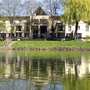 Außenansicht eines Hotels an einer Promenade mit Spiegelung im Wasser.