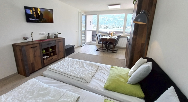 Modernes Appartement mit Blick auf den Essbereich und großes Fenster mit Bergblick.