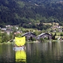 Appartementanlage am See mit Wald im Hintergrund.