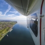 Blick aus einem Zeppelin über eine Landschaft und einen See bei klarem Himmel.