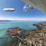 Luftaufnahme eines Zeppelins über einer Stadt an einem großen See.