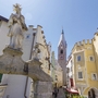 Historische Altstadt von Brixen mit Skulpturen und Kirchturm.