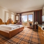 Hotelzimmer mit Doppelbett, Fensterblick und Obstteller auf einem Tisch.
