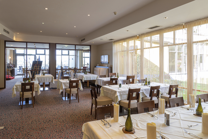 Helles Restaurant mit gedeckten Tischen und großen Fenstern im Hotel Liebmann.