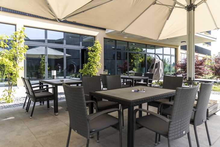 Sonnige Terrasse des Best Western Parkhotel Hagenberg mit Sitzgelegenheiten.