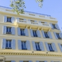 Fassade eines mehrstöckigen Gebäudes mit blauen Fensterläden und Balkonen.
