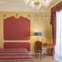 Hotelzimmer mit luxuriöser Einrichtung und bunten Vorhängen im Regina Palace Hotel.