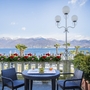 Blick auf gedeckten Tisch mit Stühlen und Seepanorama im Hotel Regina Palace, Stresa.