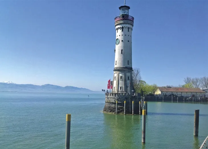 Leuchtturm auf dem Bodensee bei klarem Himmel und ruhigem Wasser.