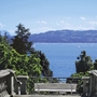Blick von Treppe auf Bodensee mit Segelbooten und Bergen im Hintergrund.