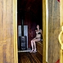 Frau entspannt in einer holzverkleideten Sauna.