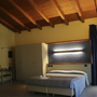 Hotelzimmer mit Doppelbett, Holzbalkendecke und Schreibtisch.